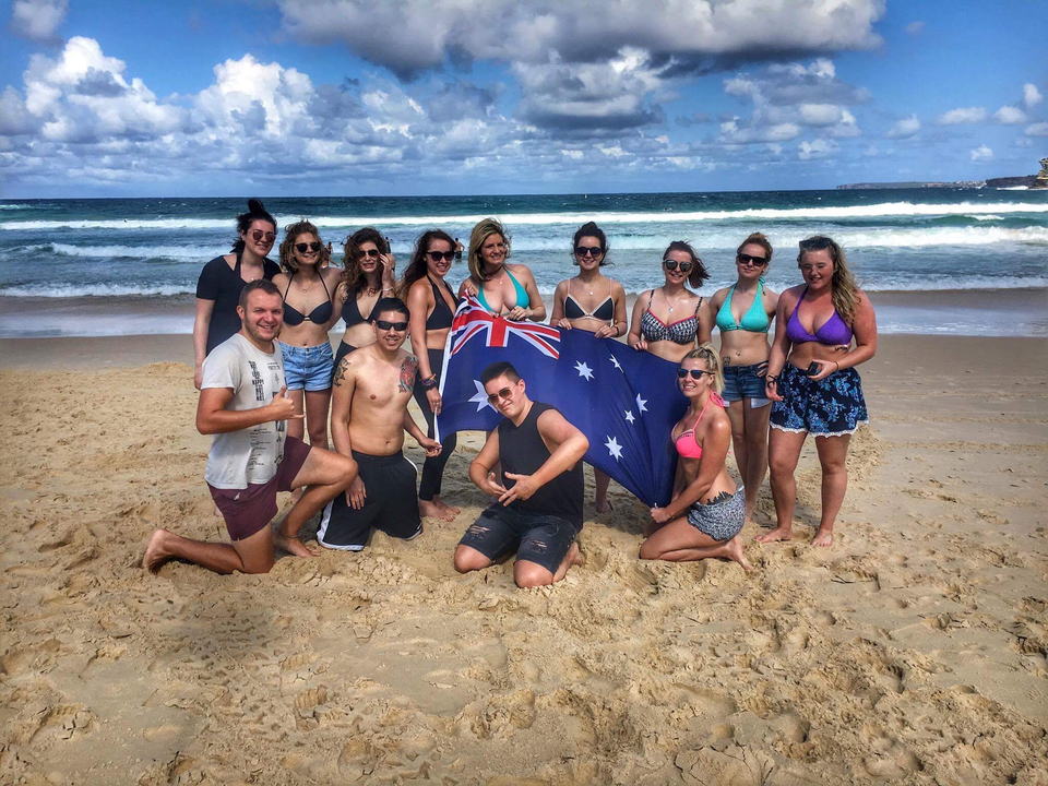 Group of people on the beach with an Australian flag.