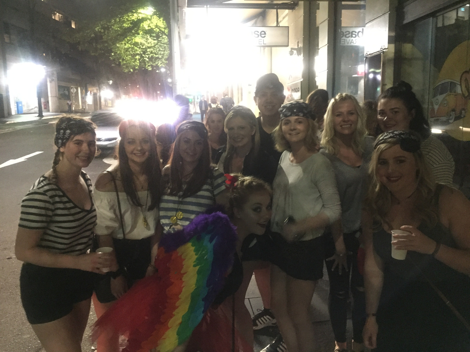 Group of people posing on a city street at night.