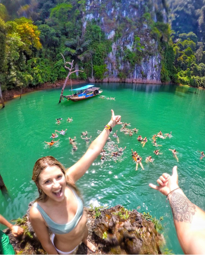 Aerial view of people swimming in a clear, green body of water.