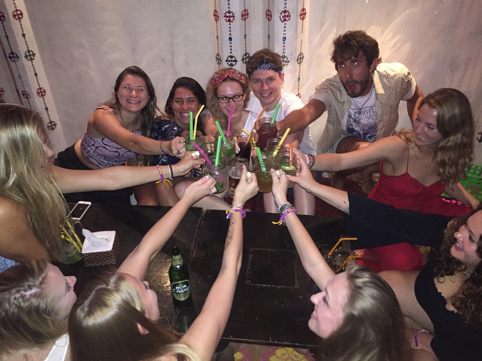 Group of friends raising glasses in a toast at a restaurant.