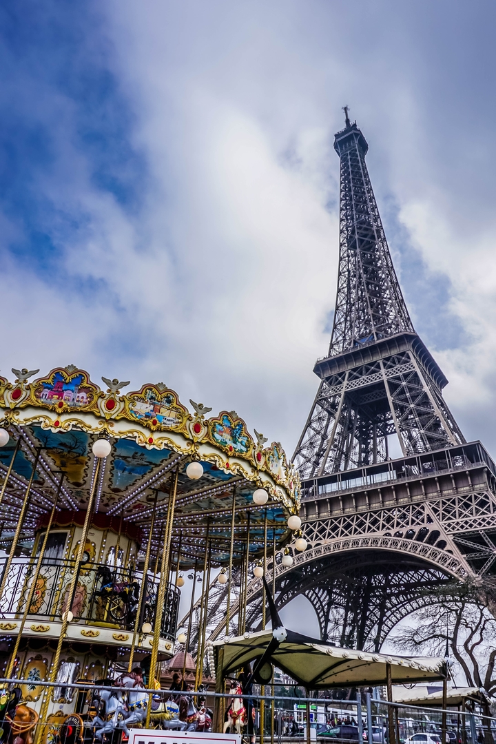 Eiffel Tower with a colorful carousel in the foreground.