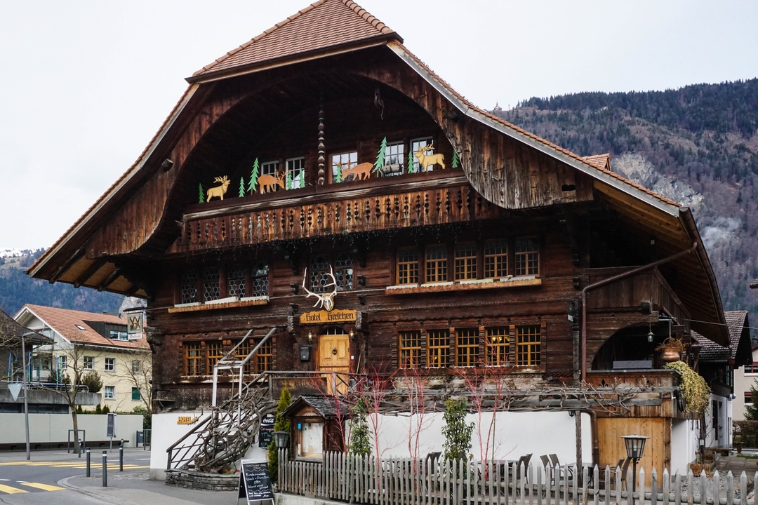 Traditional wooden building with mountains in the background.