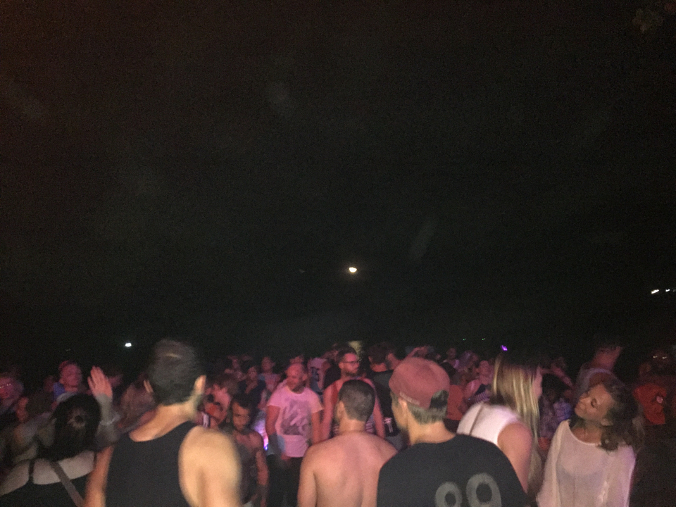 Crowded night event with people dancing.