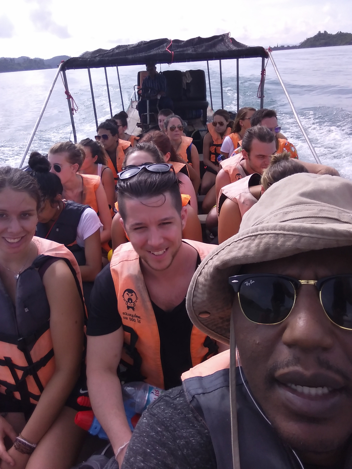 Group of people wearing life jackets on a boat.