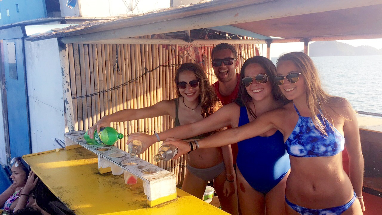 Group of people pouring drinks on a boat by the sea.