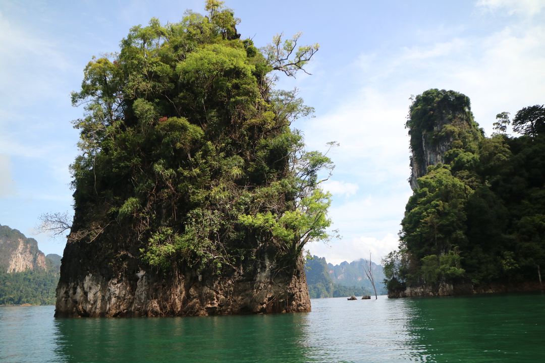 Spectacular limestone cliffs rising from a verdant lake.