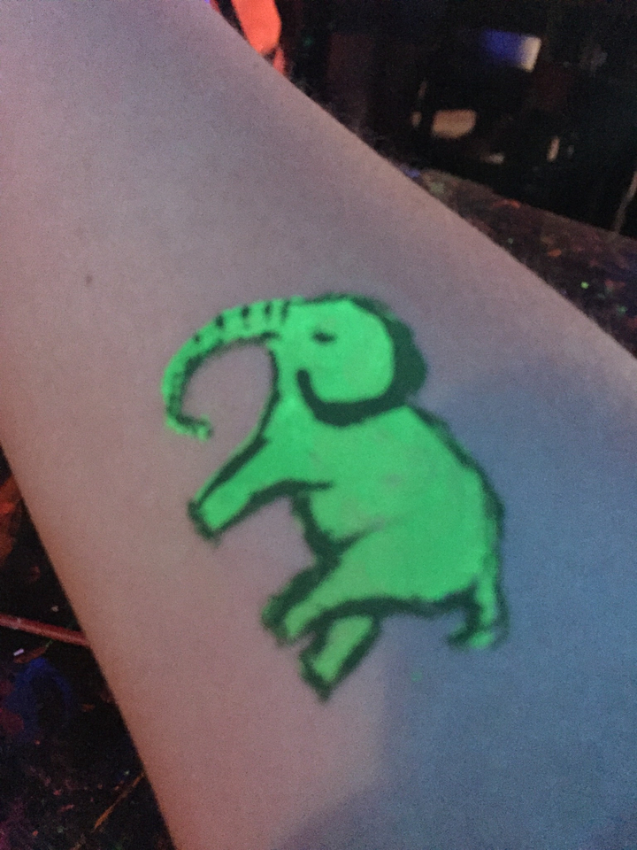 Close-up of a glowing elephant drawing on skin.