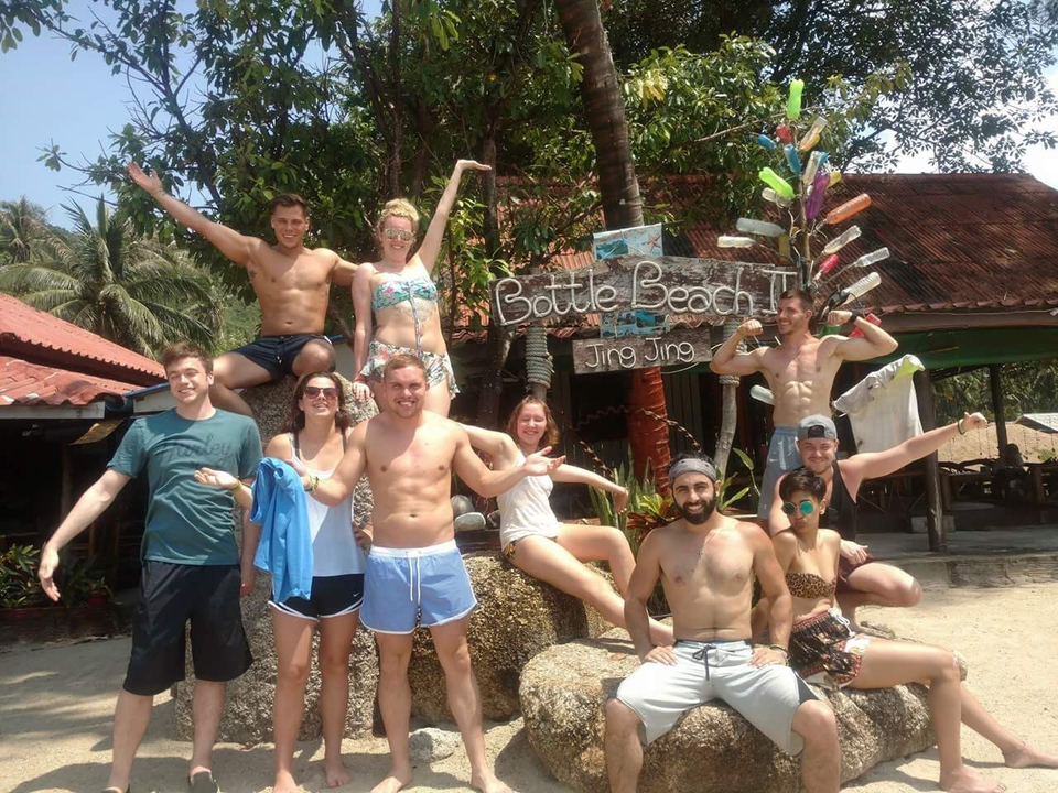 Group of people posing by a sign at Bottle Beach.