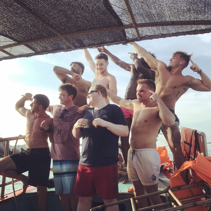 Group of smiling people posing for a photo on a boat.
