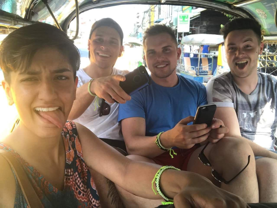 Group of friends in a vehicle taking selfies.