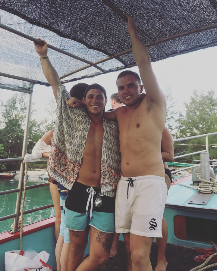 Two friends posing happily on a boat.