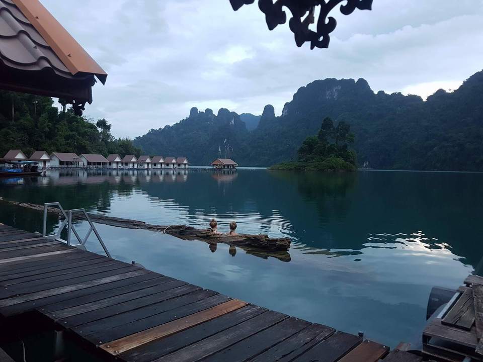 Scenic view of a lake with mountain background and two people in water.