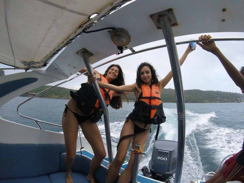 Two women posing on a boat with life jackets.