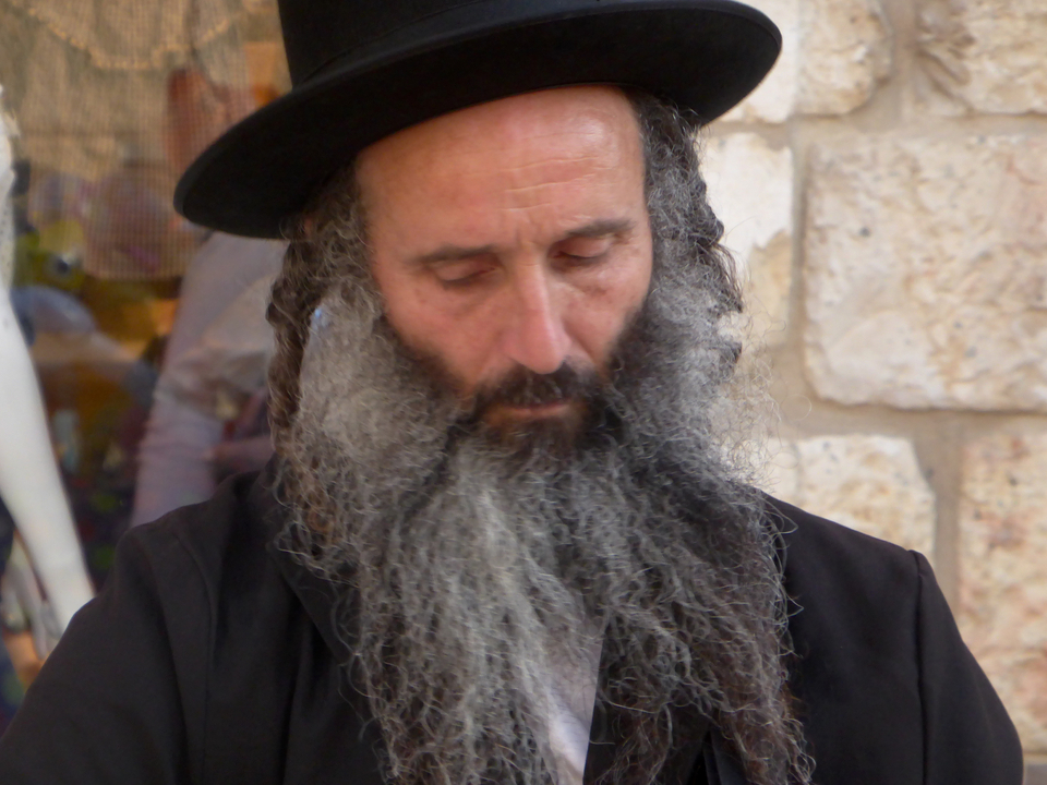 Gros plan d'une personne avec une barbe qui se concentre attentivement.