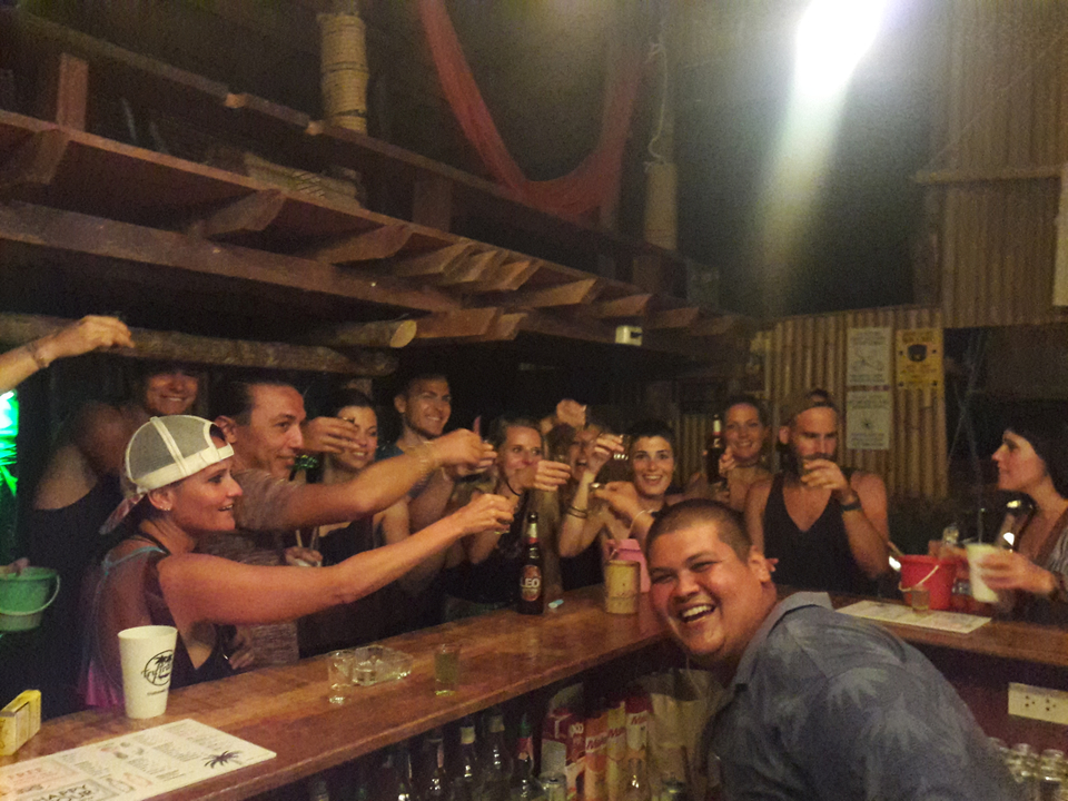 Group of people at a bar toasting and enjoying drinks.