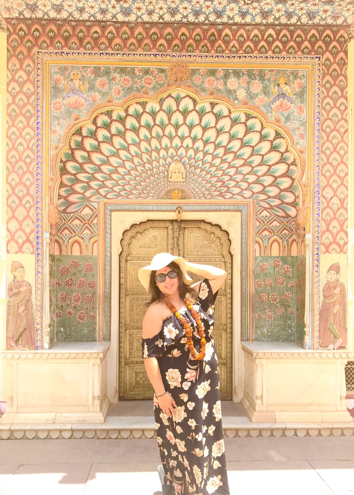 Femme posant devant une entrée magnifiquement décorée.