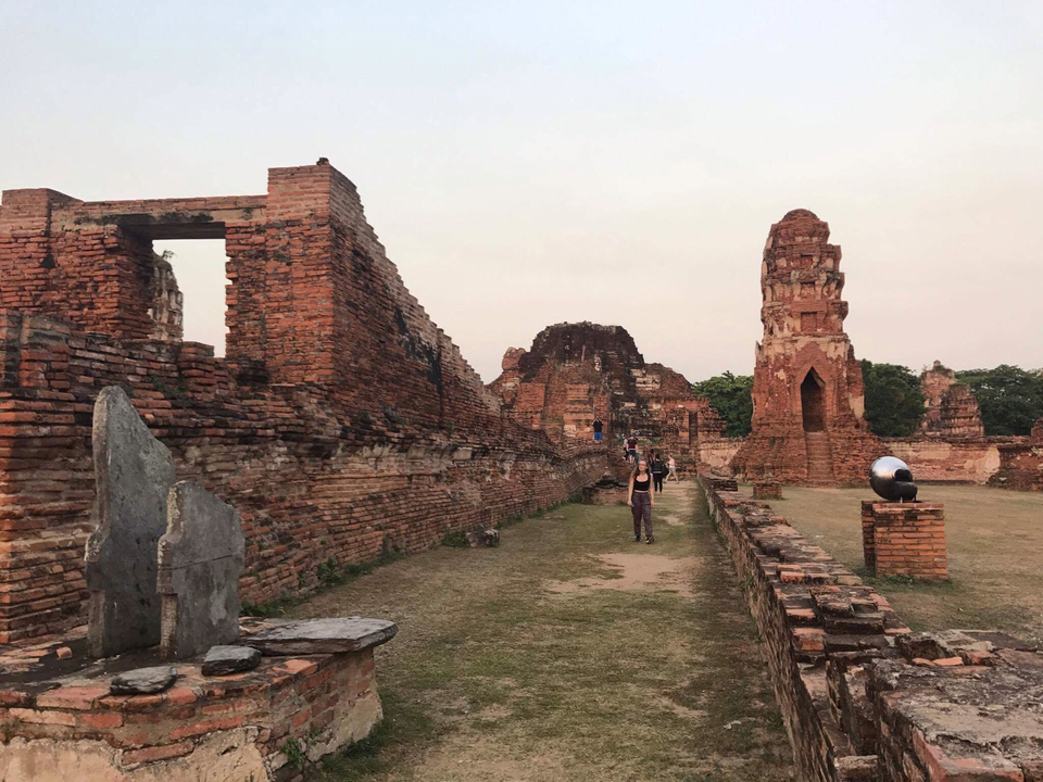 Ancient brick ruins with pathways, under a cloudy sky.