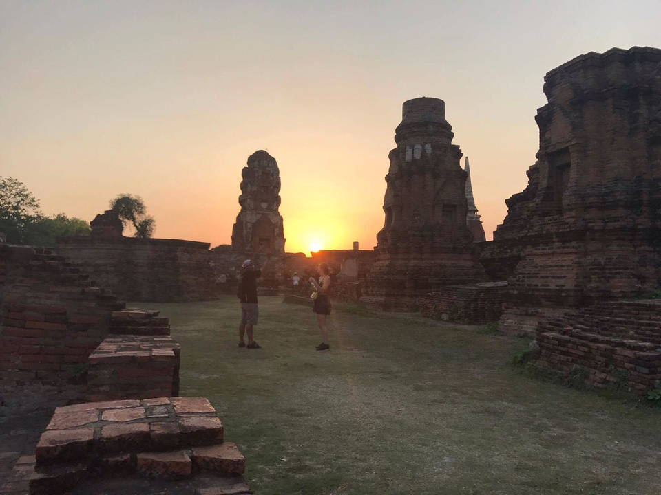 Silhouette of two people with ancient ruins at sunset.