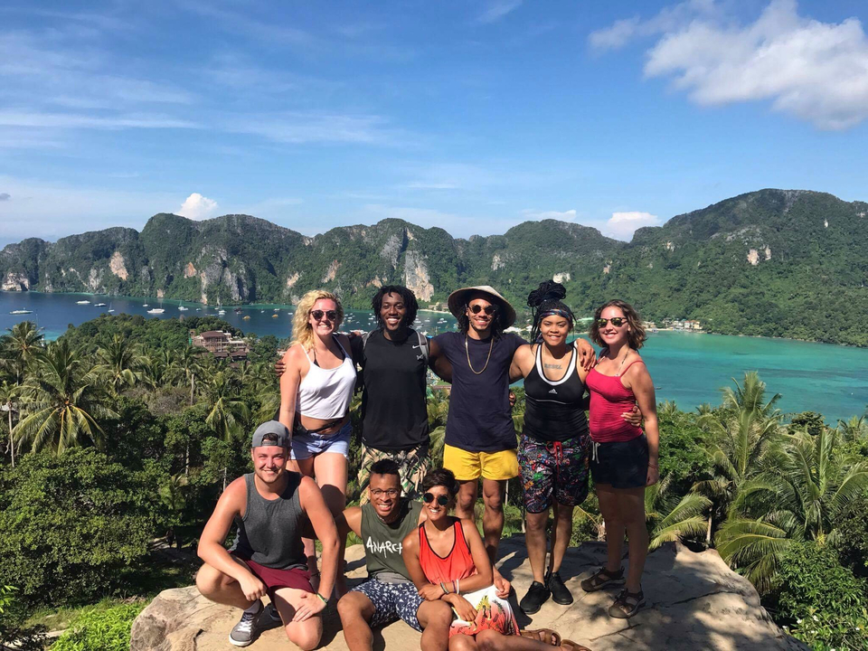 Group posing with a breathtaking view of a coastal village.