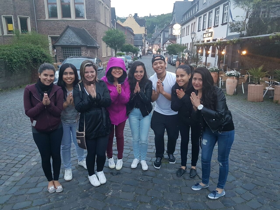 A group of friends posing on a cobblestone street with historical buildings.