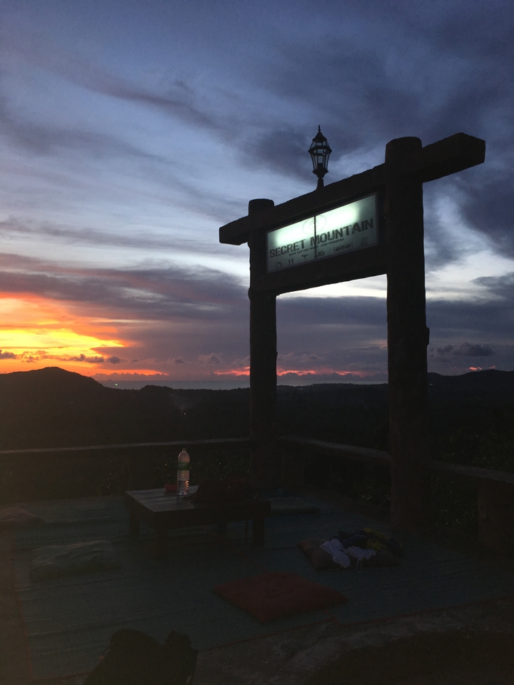 A scenic view of a sign reading 'Secret Mountain' during sunset.