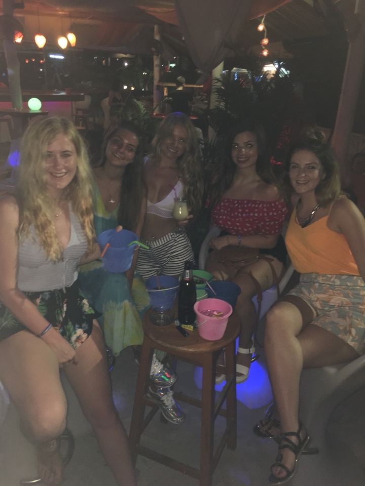 A group of friends enjoying drinks in a dimly lit setting.