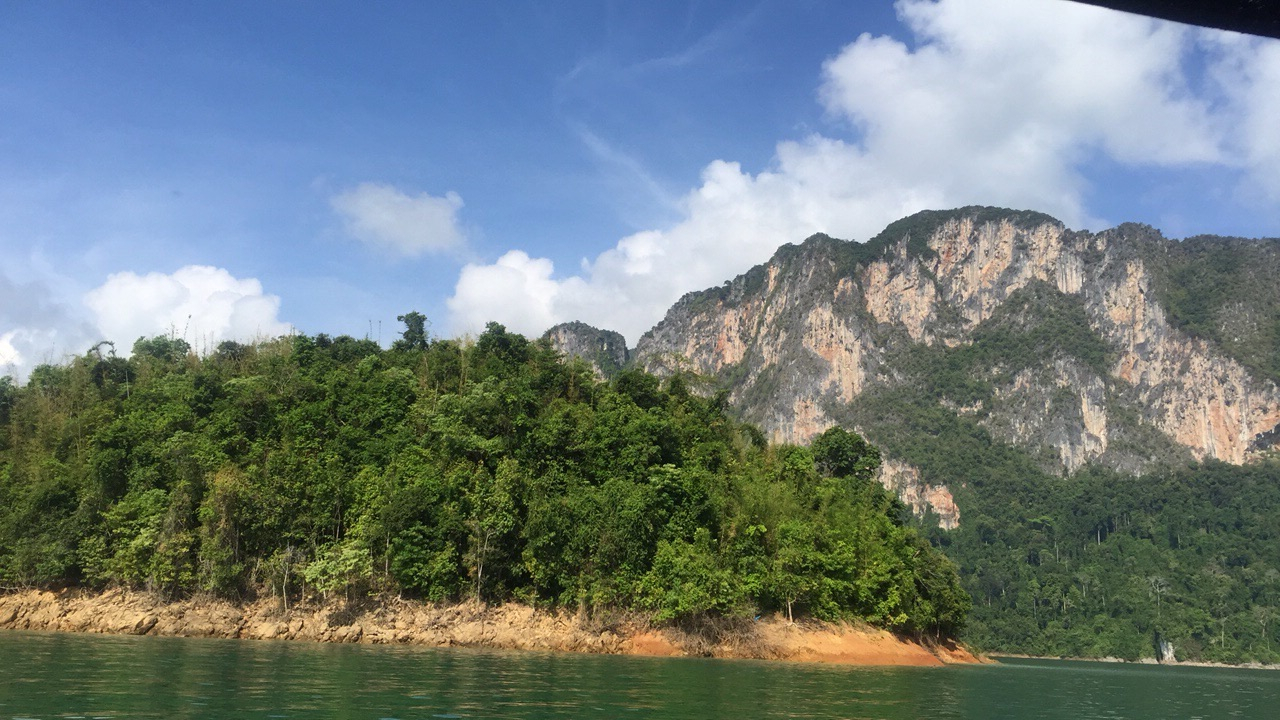 Mountainous landscape with a lake under a blue sky.