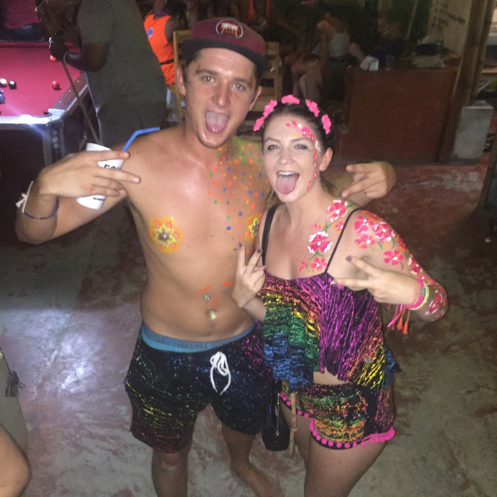Two people with neon paint in a party setting.