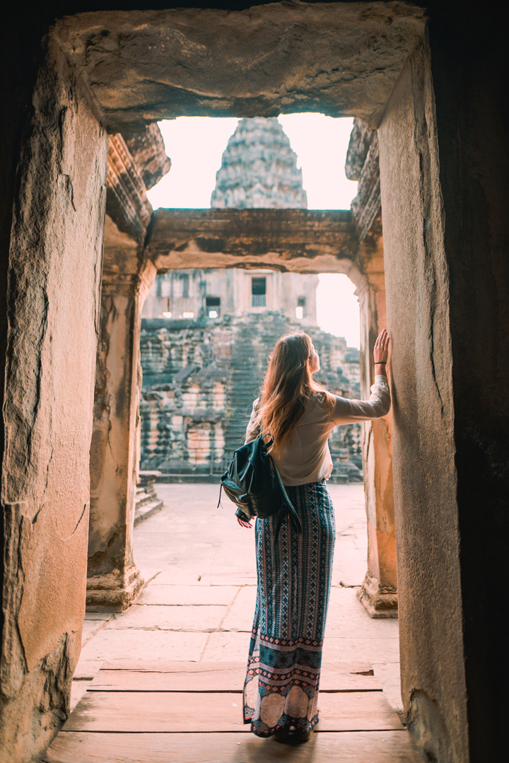 Woman gazing outwards from historic temple walls.