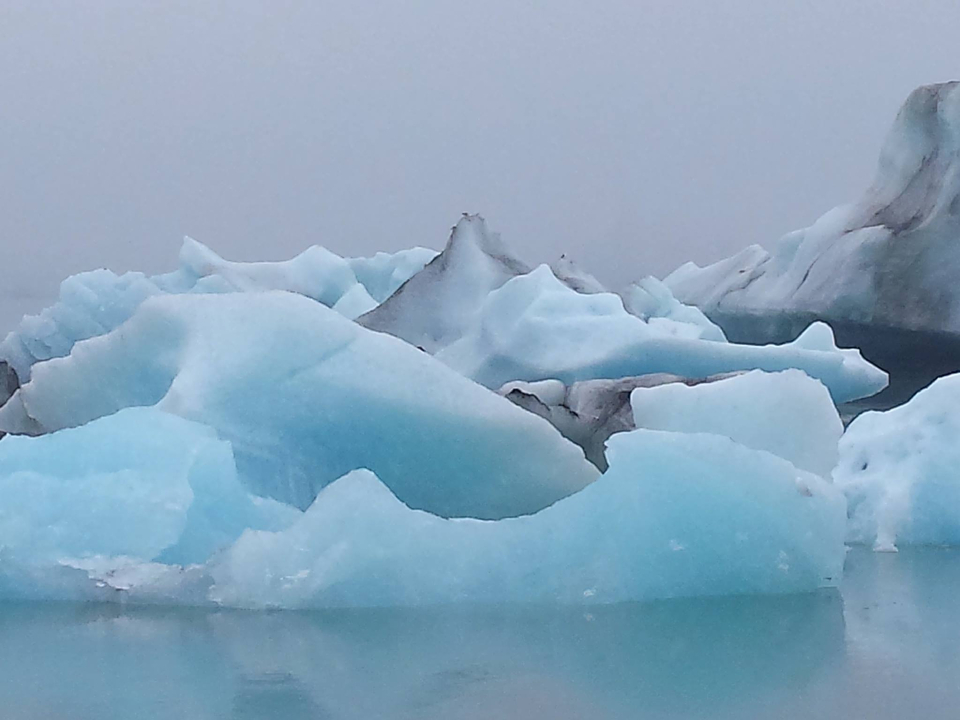 Close-up of blue icebergs floating on water.