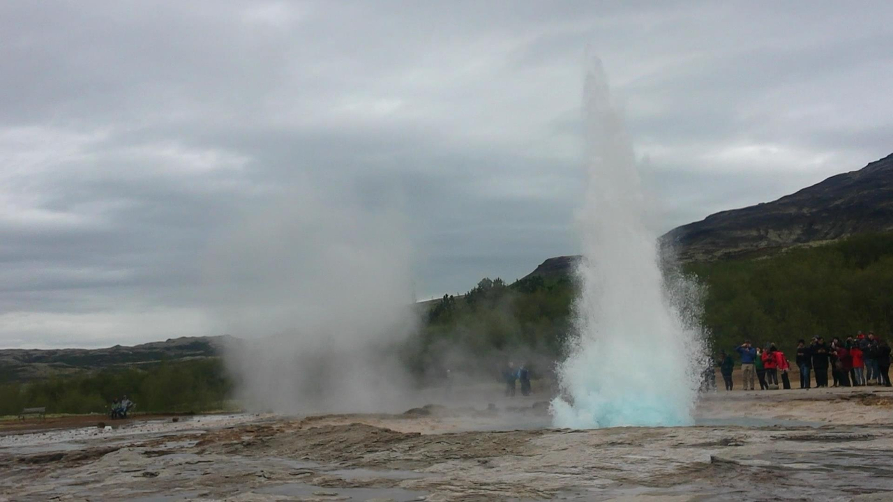 Geyser erupting with crowd watching.