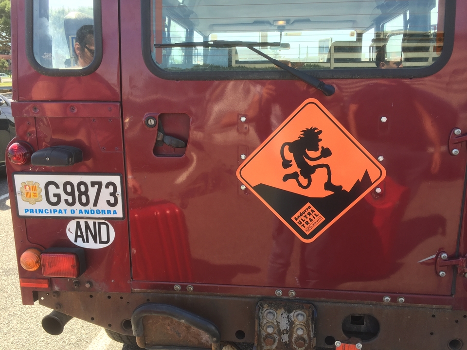 Arrière d'un véhicule avec une plaque d'immatriculation d'Andorre et un panneau humoristique.