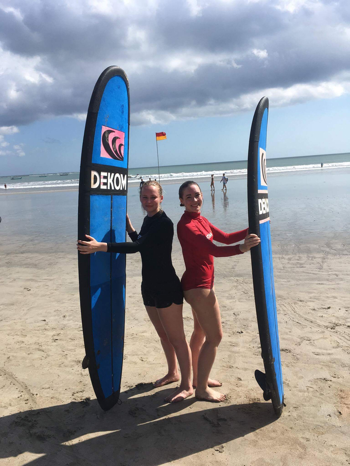 Two women holding surfboards at a beach.