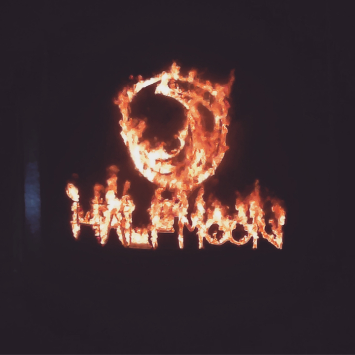 Fire-lit sign reading 'Half Moon'.