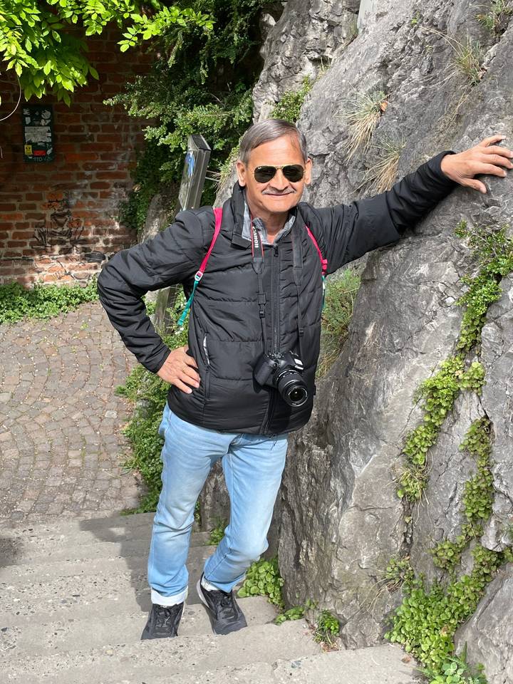 Man casually posing against a rock.