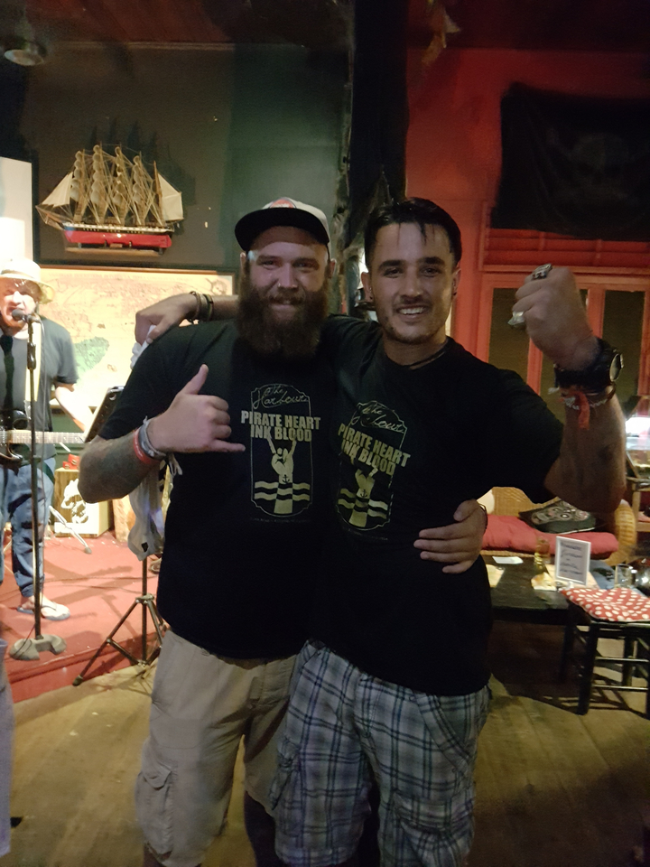 Two men posing with graphic T-shirts in an indoor setting.