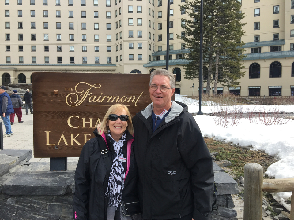 Couple devant l'enseigne d'un hôtel et la neige.