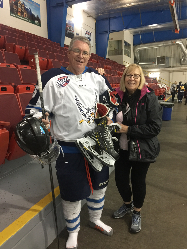Personne posant dans une arène de hockey sur glace avec un joueur.