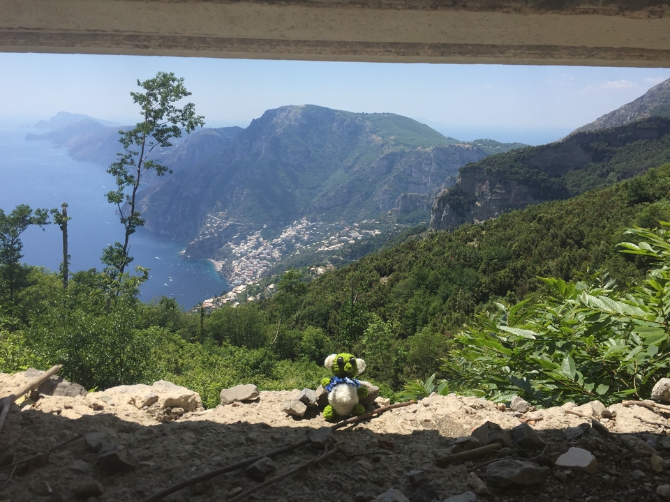 Vue panoramique d'un littoral vallonné avec un petit jouet en peluche sur un rebord.