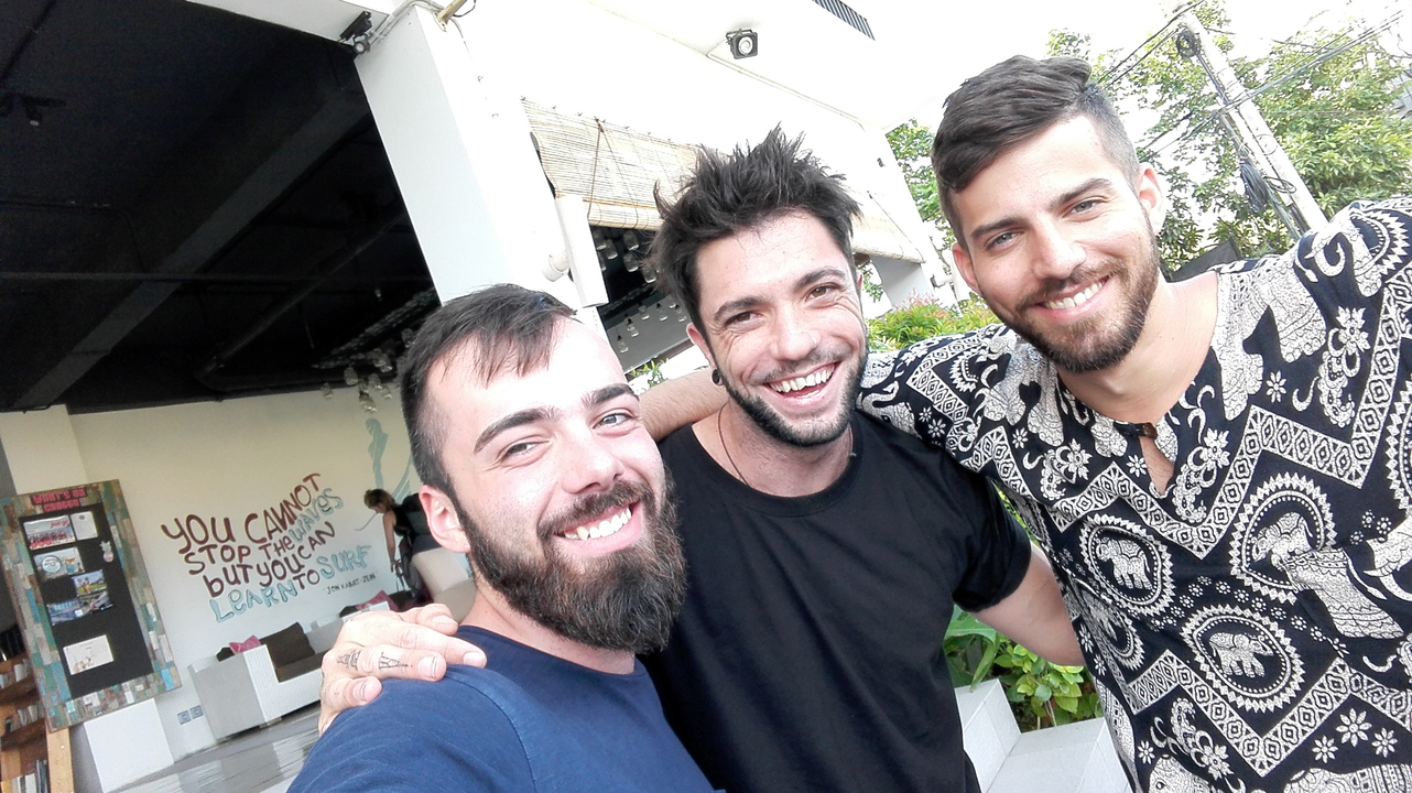Three friends smiling and posing in an outdoor setting.