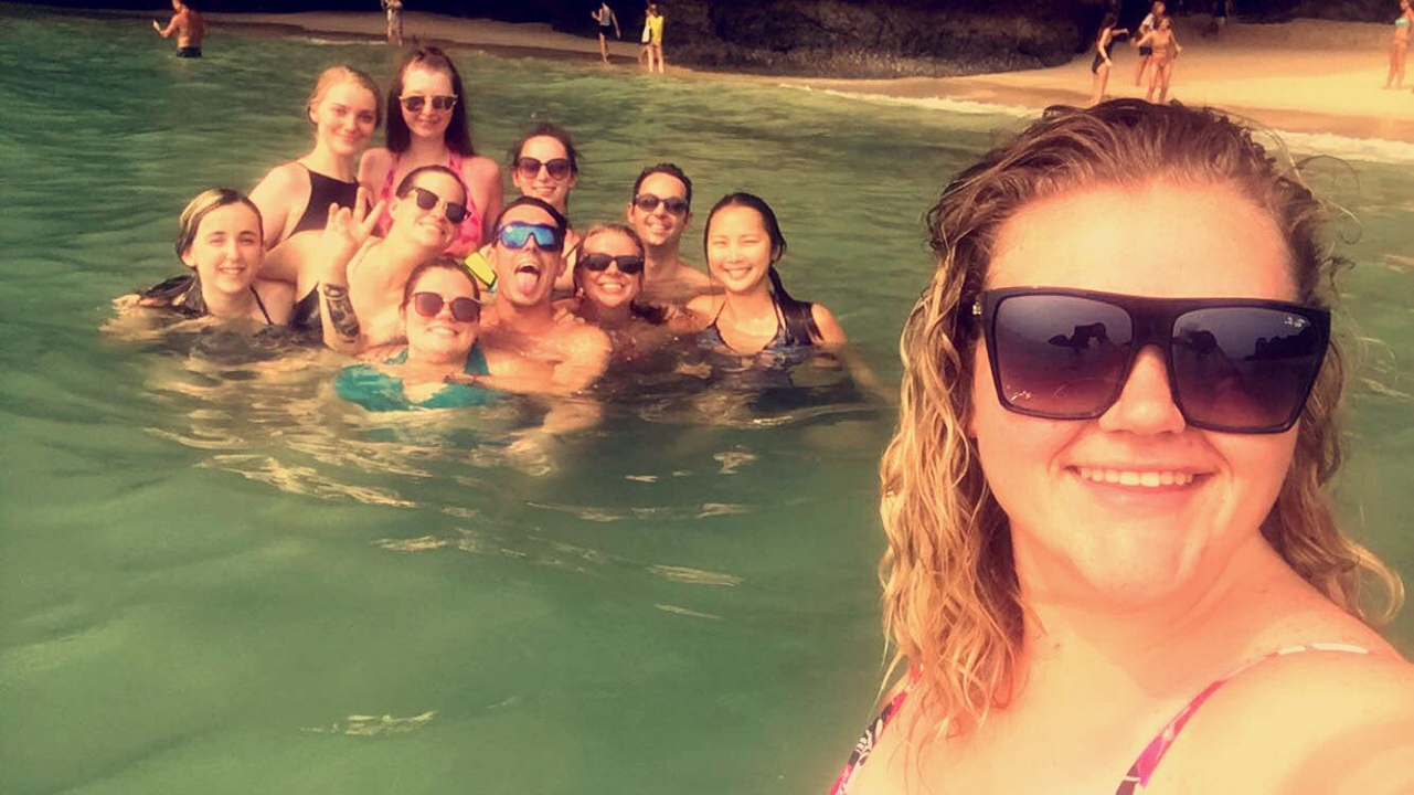 Group of people in the water at a beach.