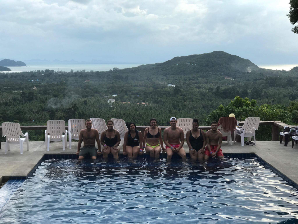 Group of people by a pool with a view of the landscape.