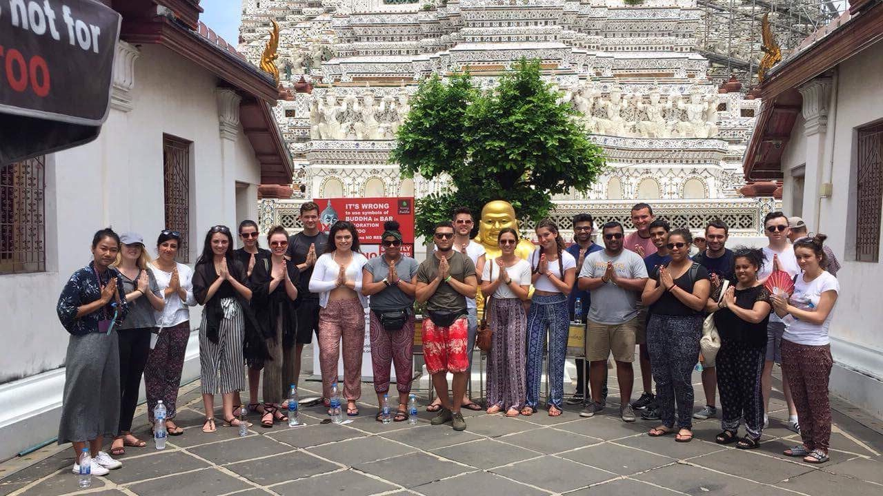 Group of people posing in front of Wat Arun temple.