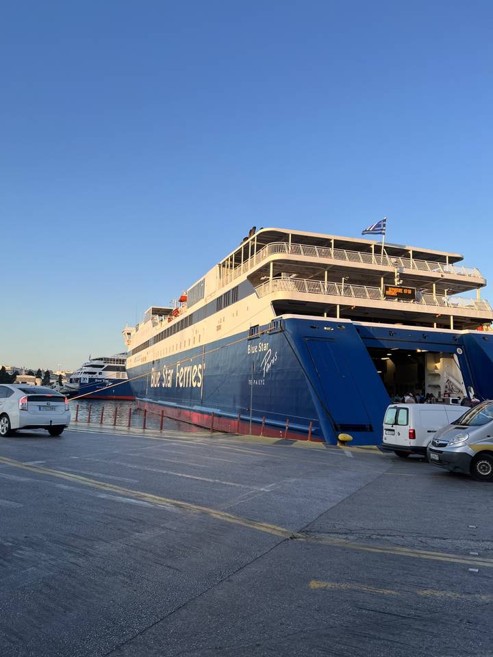 Large ferry docked at a port with blue skies.