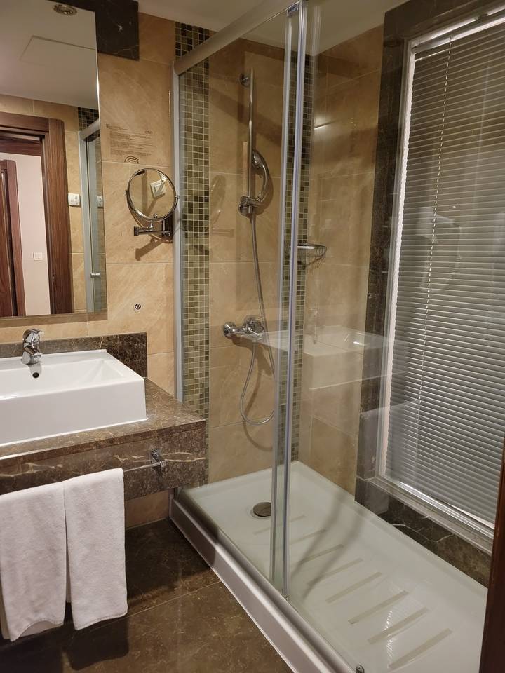 Bathroom with glass shower and marble decor.