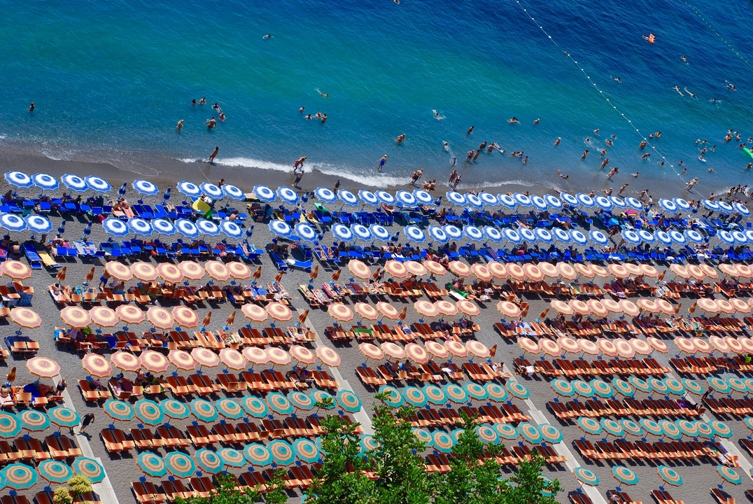 Des parasols et des chaises longues sont alignés près de l'océan.