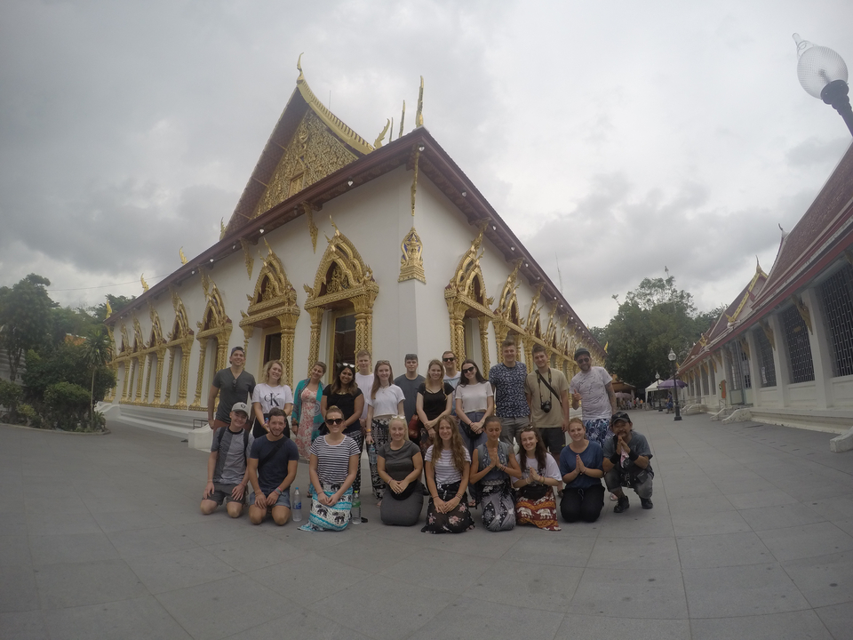 Group of people posing in front of a temple.