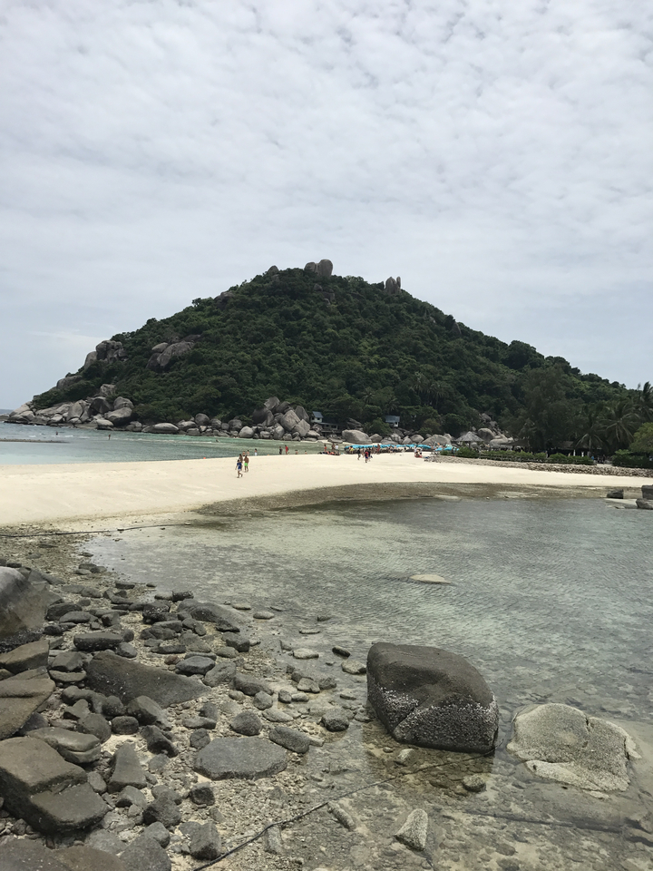 People walking on a white sandy beach.