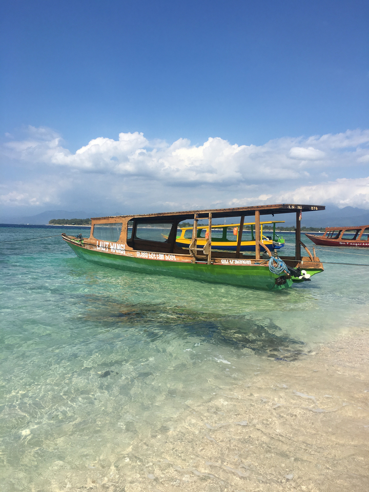 Traditional wooden boat anchored in clear waters.