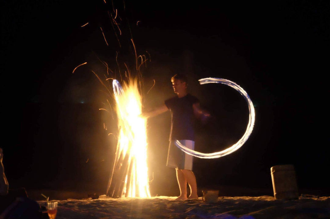 Person performing fire dance at night.